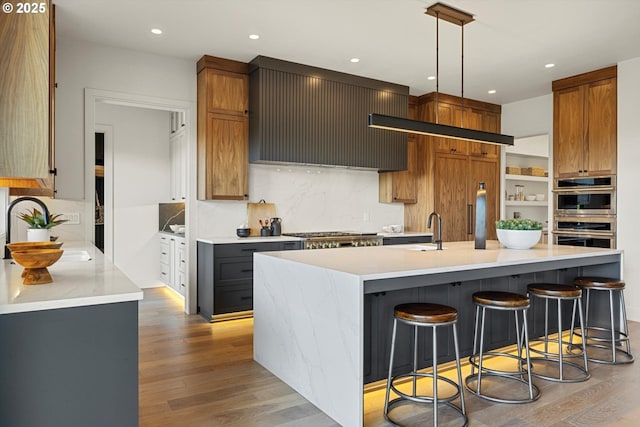 14410 Uplands Dr, Lake Oswego, OR 97034 - kitchen featuring appliances with stainless steel finishes, a sink, light countertops, tasteful backsplash, and custom exhaust hood