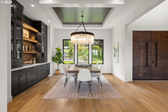 14410 Uplands Dr, Lake Oswego, OR 97034 - dining space featuring a tray ceiling, a chandelier, light wood-style floors, baseboards, and recessed lighting