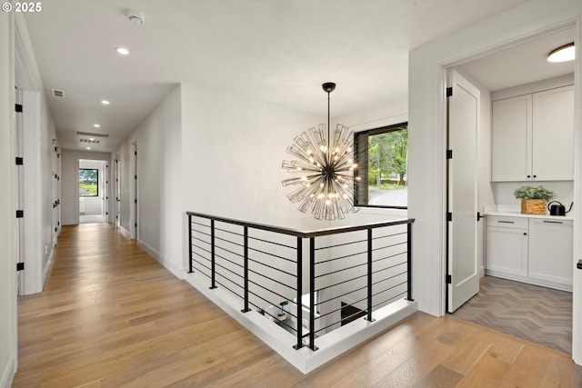14410 Uplands Dr, Lake Oswego, OR 97034 - hall with a chandelier, an upstairs landing, recessed lighting, light wood-type flooring, and baseboards