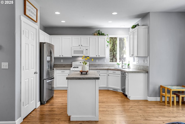 kitchen with a center island, a sink, white cabinets, and stainless steel appliances