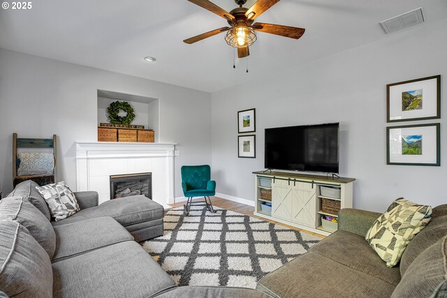 living room with a ceiling fan, recessed lighting, wood finished floors, a tile fireplace, and visible vents