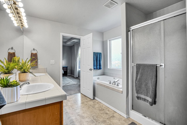 full bath with double vanity, a garden tub, visible vents, a shower stall, and a sink