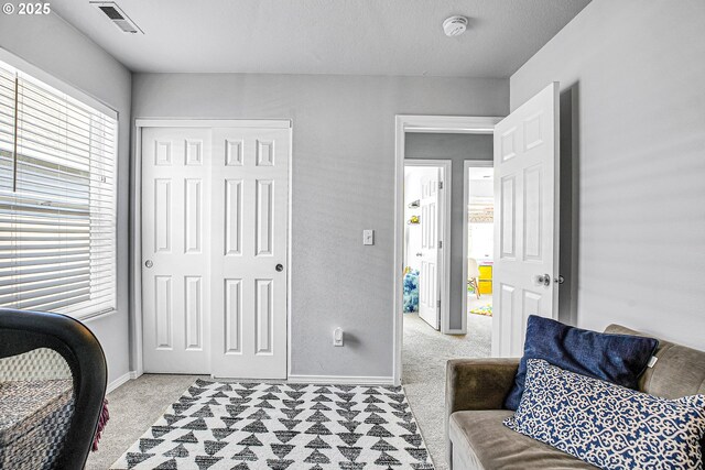 bedroom with visible vents, multiple windows, and light colored carpet