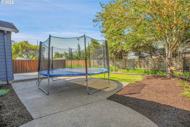 view of patio with a fenced backyard and a trampoline