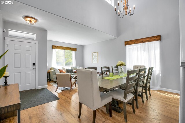 dining room featuring baseboards, a chandelier, and light wood-type flooring
