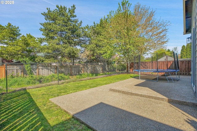 view of yard with a fenced backyard, a trampoline, and a patio area