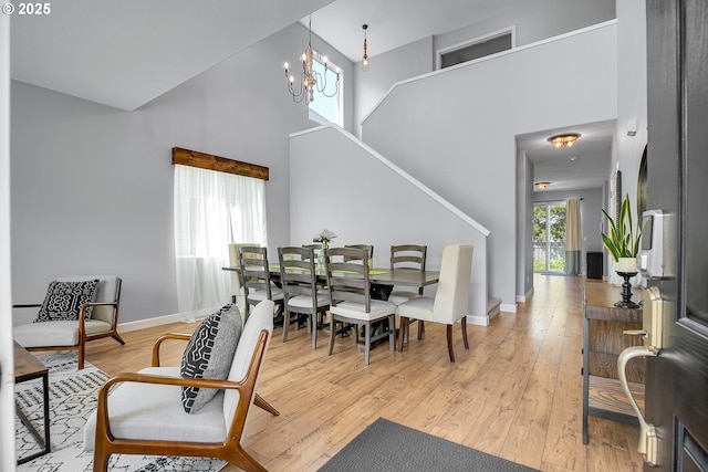 417 W Kemper Crest Dr, Newberg, OR 97132 - dining room featuring a towering ceiling, stairs, light wood-style floors, baseboards, and a chandelier