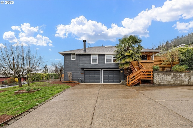 exterior space with an attached garage, fence, stairs, a front yard, and driveway