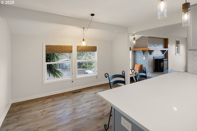 dining area featuring lofted ceiling, wood finished floors, baseboards, and visible vents