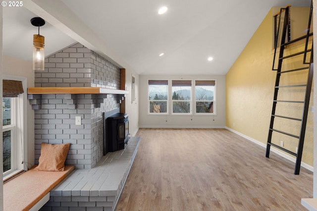 unfurnished living room with light wood finished floors, baseboards, lofted ceiling, recessed lighting, and a wood stove