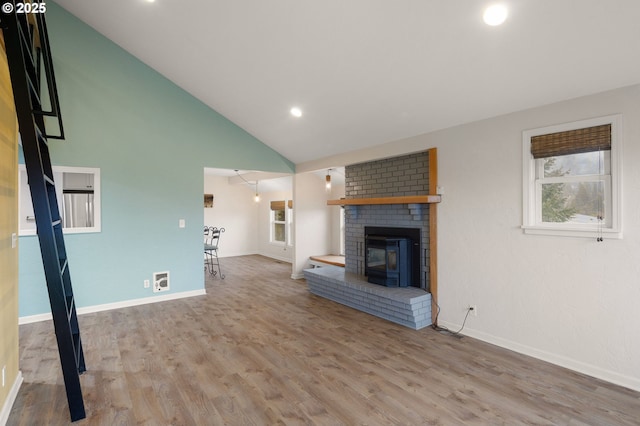 unfurnished living room featuring lofted ceiling, recessed lighting, wood finished floors, and baseboards