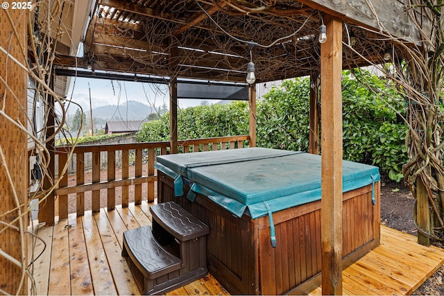 deck with a mountain view and a hot tub