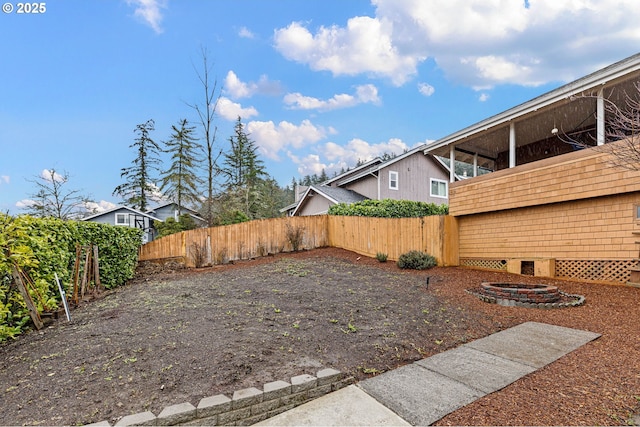 view of yard with a fire pit and fence