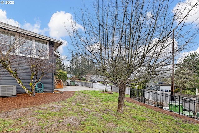 view of yard with a patio, central AC unit, and fence