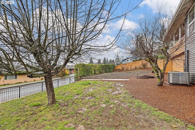 view of yard with central AC unit and fence