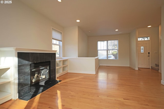 living area featuring a tiled fireplace and wood finished floors