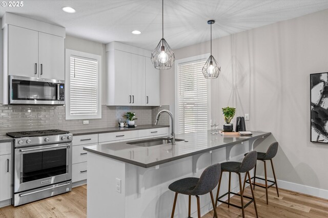 9014 SW Steens Ln, Portland, OR 97225 - kitchen featuring stainless steel appliances, a sink, tasteful backsplash, a breakfast bar area, and recessed lighting