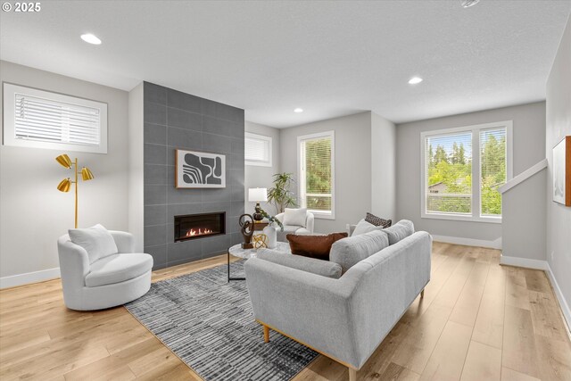 9014 SW Steens Ln, Portland, OR 97225 - living area featuring a tile fireplace, light wood-style flooring, baseboards, healthy amount of natural light, and recessed lighting