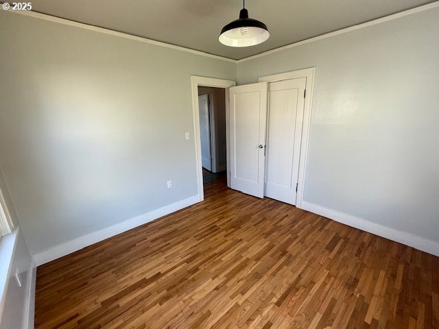 351 Juniper St, Junction City, OR 97448 - unfurnished bedroom featuring baseboards, ornamental molding, a closet, and wood finished floors