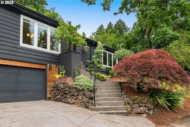 6945 SW 7th Ave, Portland, OR 97219 - view of front facade featuring stairway, driveway, and a garage