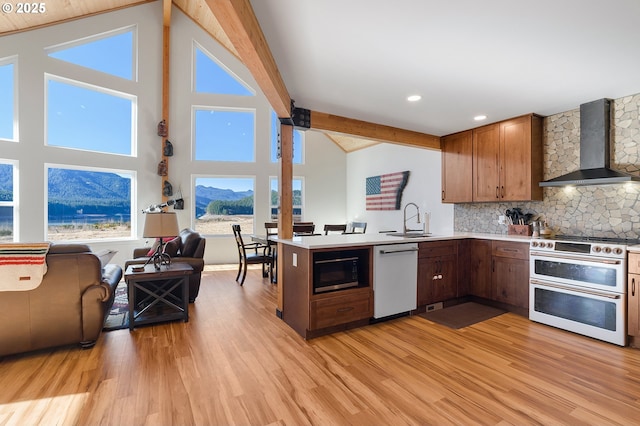 kitchen with black microwave, white dishwasher, a sink, double oven range, and wall chimney exhaust hood