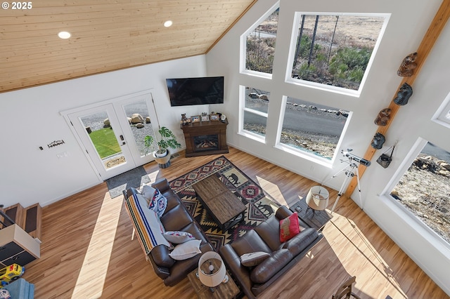 living area with wood ceiling, wood finished floors, french doors, a fireplace, and high vaulted ceiling