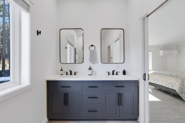 bathroom with a sink, a wall mounted AC, ensuite bath, and double vanity