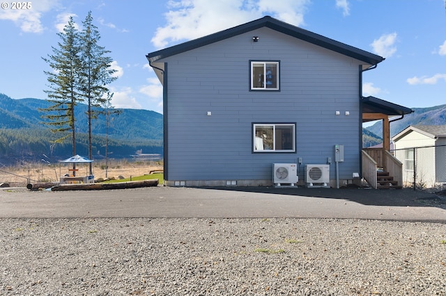 back of house with ac unit and a mountain view