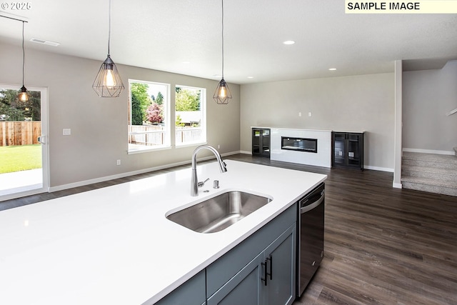 kitchen featuring gray cabinets, dark hardwood / wood-style floors, sink, dishwashing machine, and hanging light fixtures