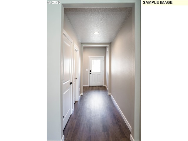 hall featuring dark hardwood / wood-style flooring and a textured ceiling