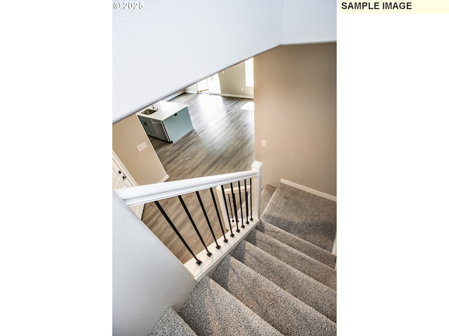 staircase featuring vaulted ceiling and wood-type flooring