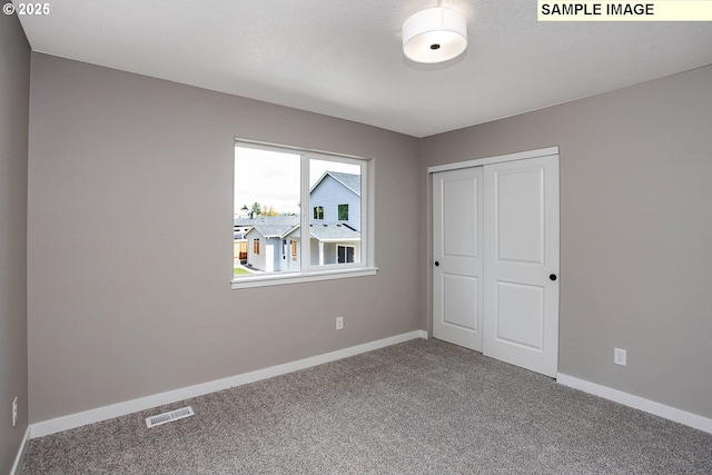 unfurnished bedroom featuring a closet, a textured ceiling, and carpet