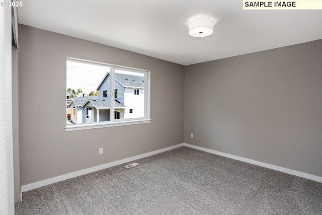 carpeted empty room featuring a textured ceiling