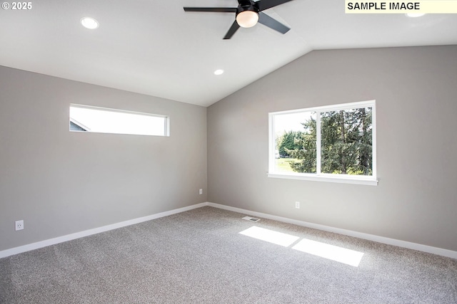 carpeted spare room with ceiling fan and vaulted ceiling