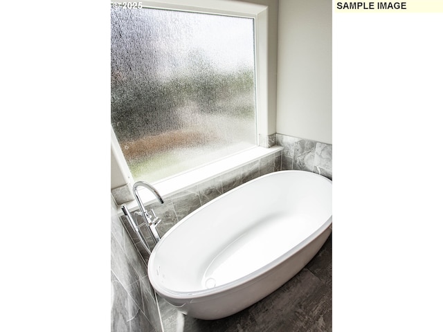 bathroom with a bath and tile walls