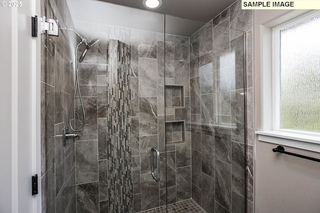 bathroom featuring a shower with door and a wealth of natural light