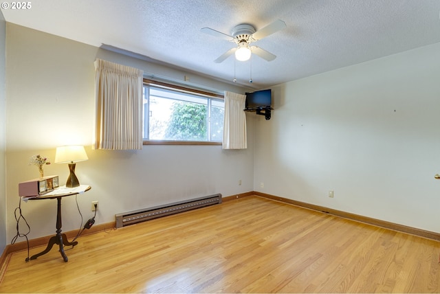 unfurnished room with ceiling fan, light hardwood / wood-style floors, a textured ceiling, and baseboard heating