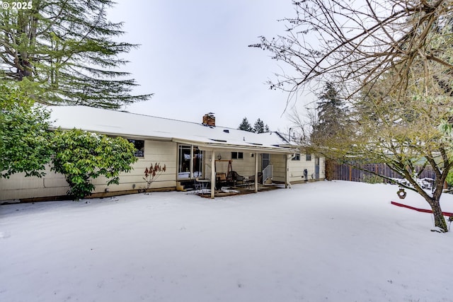 view of snow covered back of property