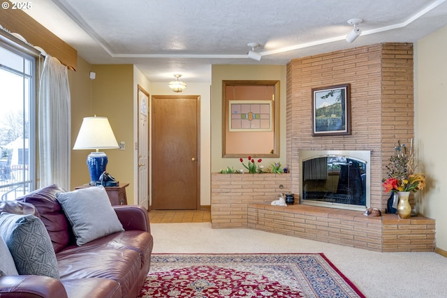 carpeted living room with a brick fireplace and a textured ceiling