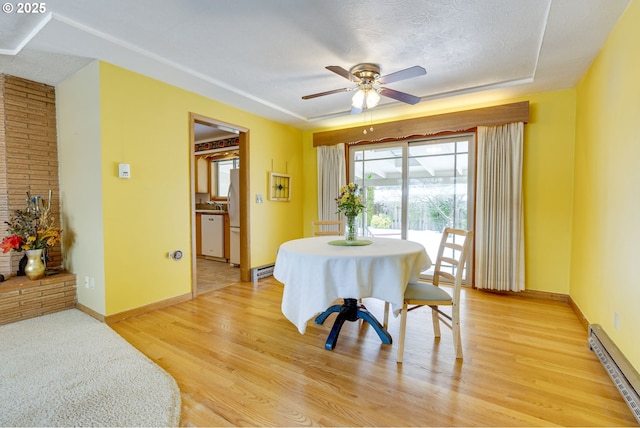 dining room featuring light hardwood / wood-style flooring, ceiling fan, and baseboard heating