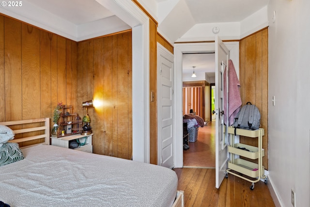 bedroom with wood walls and wood finished floors