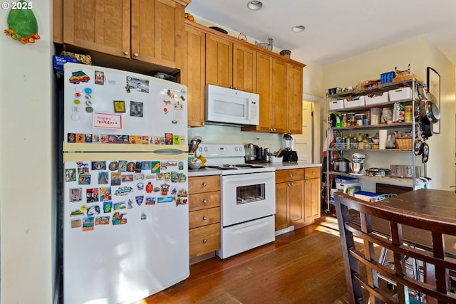 kitchen with white appliances, light countertops, dark wood finished floors, and brown cabinetry