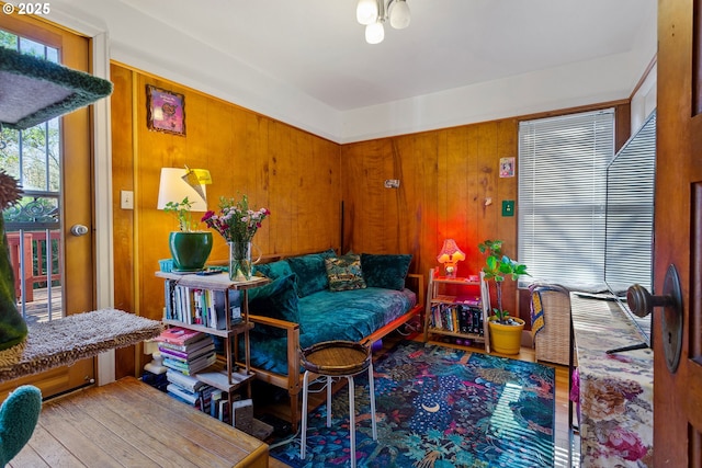 living area featuring wood walls and wood finished floors