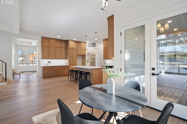 dining area with french doors, light wood finished floors, visible vents, and recessed lighting