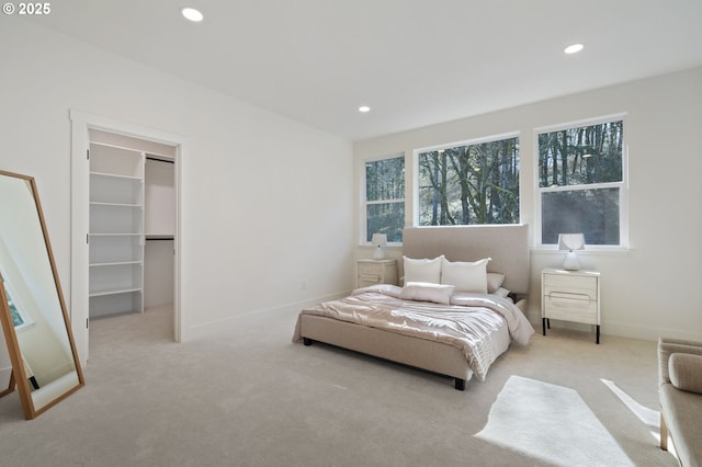 bedroom featuring carpet, baseboards, a walk in closet, and recessed lighting