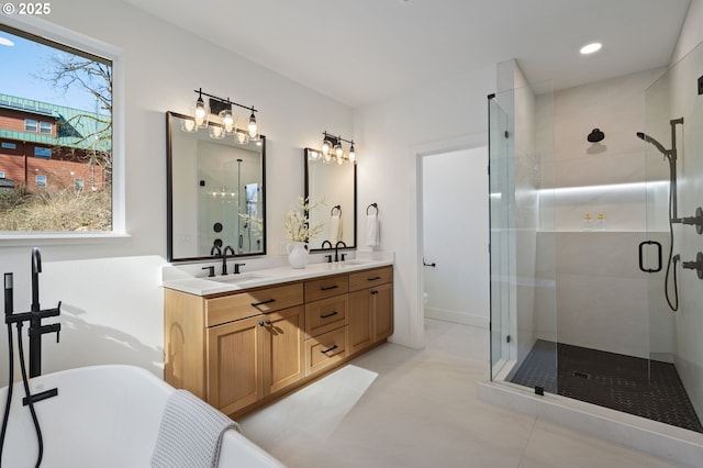 bathroom with a sink, a shower stall, a freestanding bath, and double vanity