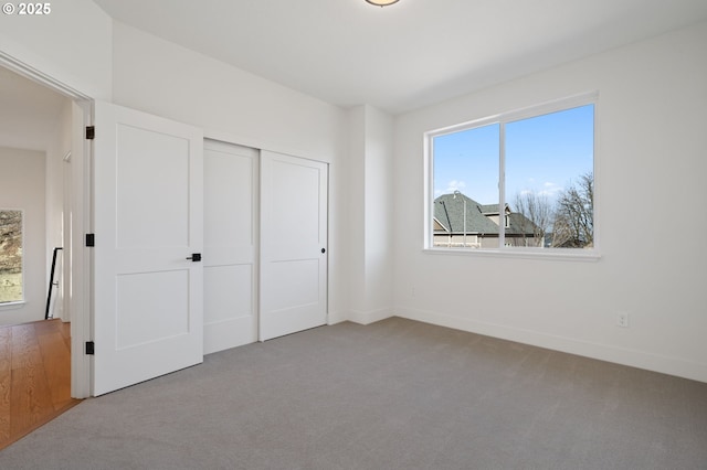 unfurnished bedroom with carpet, baseboards, and a closet