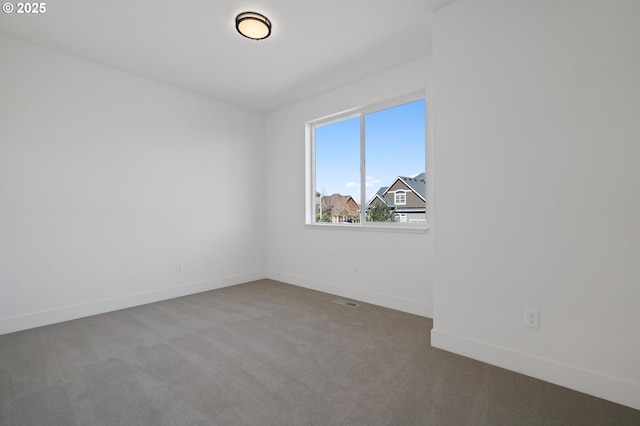 empty room featuring carpet floors and baseboards