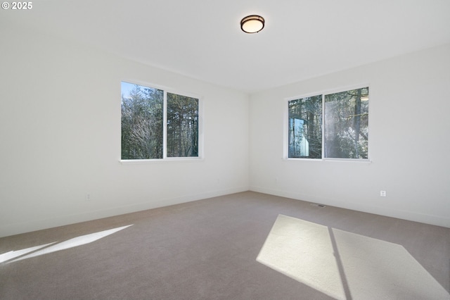 unfurnished room with carpet and baseboards