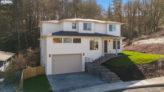 view of front of home featuring a garage, fence, and driveway